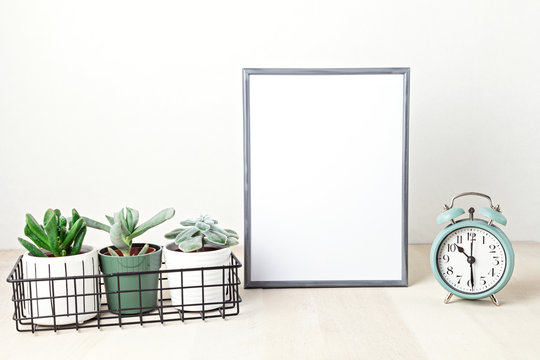 Poster frame mockup, front view, with decor elements, house plants, flowers and blank copy space over the white wall