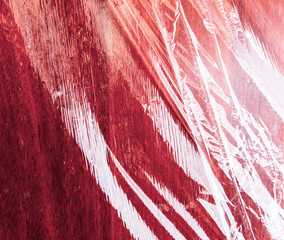 Plastic films on a red wooden board.