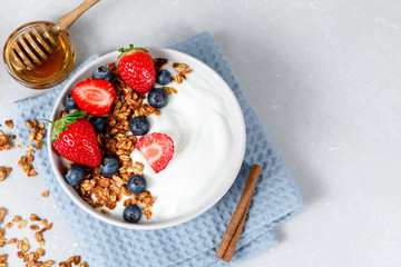 Homemade oatmeal granola bowl with greek yogurt, berries, honey and nut
