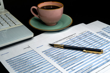 The report summarizes the results of business operations, pen, cup of coffee on desk of investor.