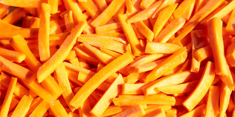 Fresh orange carrots sliced as a background.