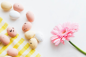 Obraz na płótnie Canvas Chocolate Easter eggs and pink gerbera flowers flatlay