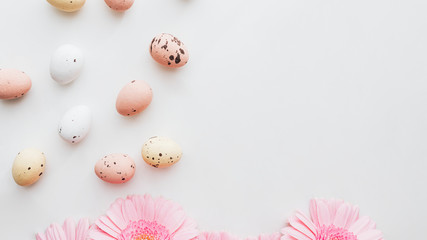 Fototapeta na wymiar Chocolate Easter eggs and pink gerbera flowers flatlay