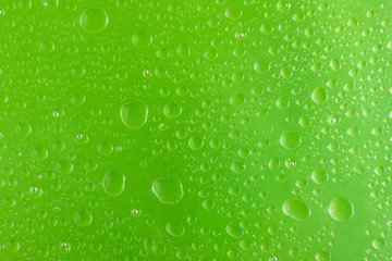 background for design of water drop close up on a green surface