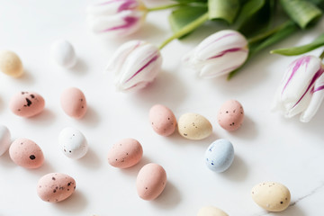 Obraz na płótnie Canvas Chocolate Easter eggs and tulips flatlay