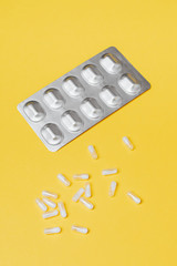 Pills and medication on a yellow background