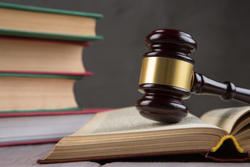 Wooden gavel and books on wooden table - law and auction concept