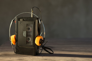 Old portable cassette player and headphones on a abstract background. Vintage advertisement style