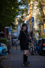 Fototapeta premium Japanese woman riding skateboard in sidewalk