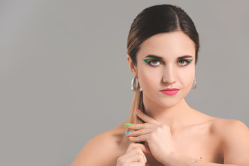 Young woman with beautiful manicure on grey background