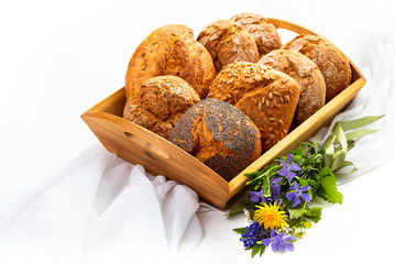 Buns on a wooden tray and wildflowers. Isolate on white background