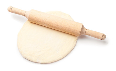 Fresh dough and rolling pin on white background