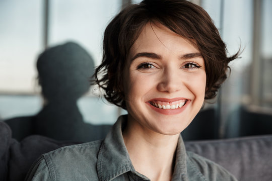 Image of brunette cute happy woman smiling and looking at camera