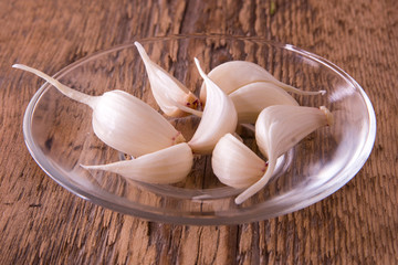 garlic, green, young, on a plate and wooden background