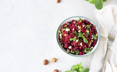 Warm buckwheat, beetroot, nuts and herbs salad, light grey concrete background. Vegetarian and vegan food. Healthy food concept. Top view.