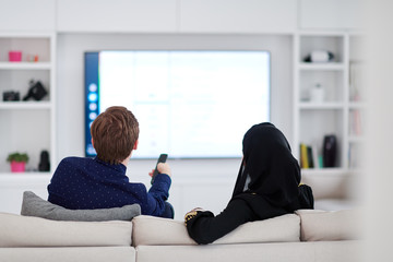 young muslim couple watching TV together