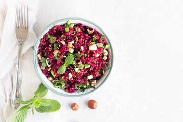 Warm buckwheat, beetroot, nuts and herbs salad, light grey concrete background. Vegetarian and vegan food. Healthy food concept. Top view.