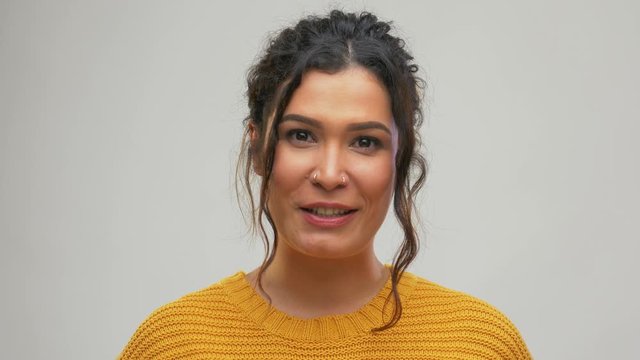 video blogging, communication and people concept - happy smiling young woman with pierced nose talking over grey background