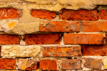 Old brick wall masonry of red brick behind plastered.