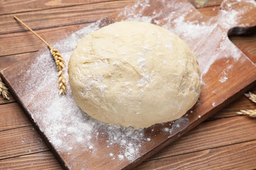 Fresh dough on wooden background