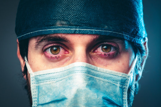 Coronavirus, medico stanco che piange. Primo piano.