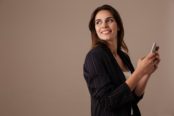 Photo of happy businesswoman smiling and using cellphone