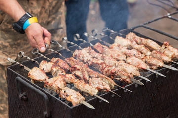Man flips, cooks kebab on the grill, outdoors