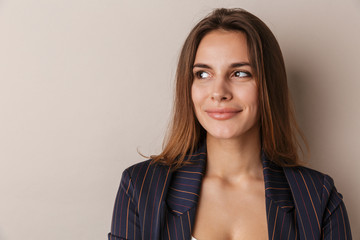 Obraz premium Photo of joyful businesswoman in formal suit smiling and looking aside