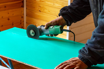In the manâ€™s hands is a cutting machine.