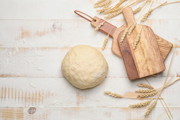 Fresh wheat dough on white wooden background