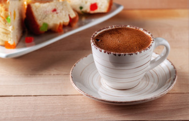 Cup of fresh aromatic coffee with homemade cakes on a wooden table