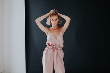 Portrait of a beautiful fashionable woman in a pink jumpsuit
