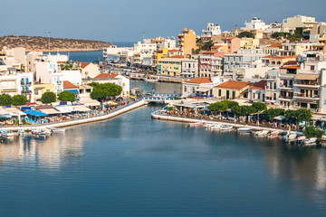 Obraz premium top view of a quiet bay and the Greek resort town of Agios Nikolaos on a sunny summer day
