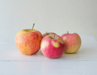 Ripe homemade seasonal apples on white wooden background