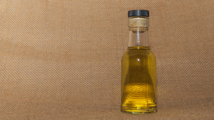 The small bottle of alcohol or sanitizer on the sackcloth baclground. Space for text.