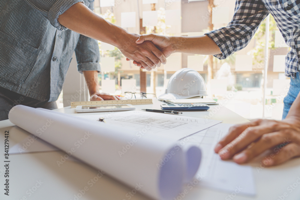 Poster architect and engineer construction workers shaking hands while working for teamwork and cooperation