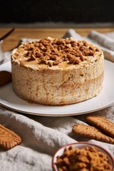 Vertical shot of a delicious lotus cookie cake with caramel with cookies on the table