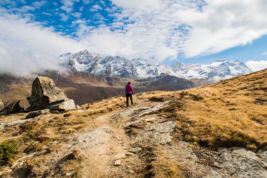 Rear View Of Woman Walking On Mountain Against Sky