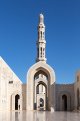 Minaret towering over archways of Sultan Qaboos Grand Mosque in Muscat, Oman