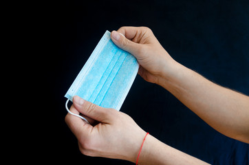 Medical protective blue masks in the hands of a man