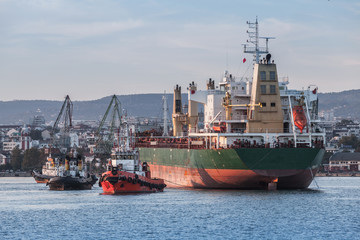 Maneuvers of a huge bulk carrier and tug boats
