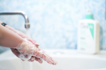 A woman washes her hands with soap. Soap foam on the hands. Close-up.