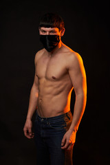 Fototapeta na wymiar muscular man in black medical mask with naked torso