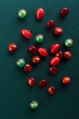 Vertical image.Red and green buttons for luxury clothing on the dark green surface