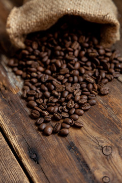 Bag of coffee on a wooden table. Coffee beans are poured. Top view, place for text. Coffee background. Food and drink. © Real_life