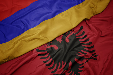 waving colorful flag of albania and national flag of armenia.