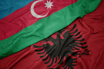 waving colorful flag of albania and national flag of azerbaijan.
