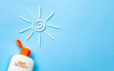 Sunscreen. Cream in the form of sun on blue background with white tube. Copy space for text