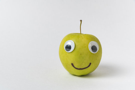 Apple smiley on white background. Apple with Googly eyes and drawn smile.