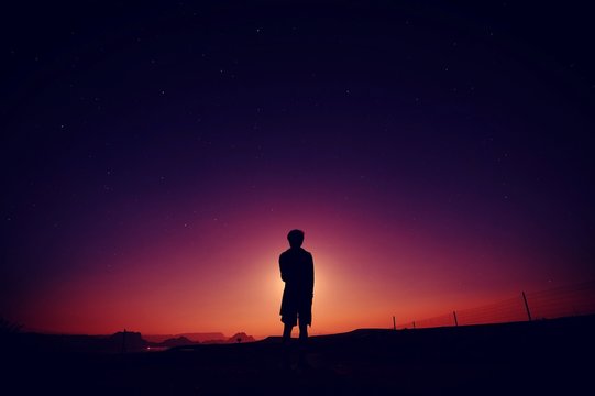 Silhouette Man Standing On Field Against Sky At Night